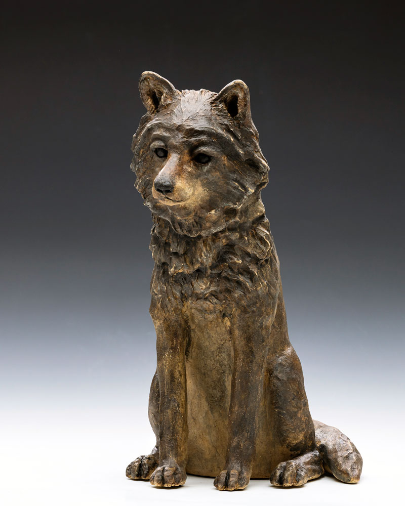 A stoneware gray wolf pup sculpture by artist Tina Curry.