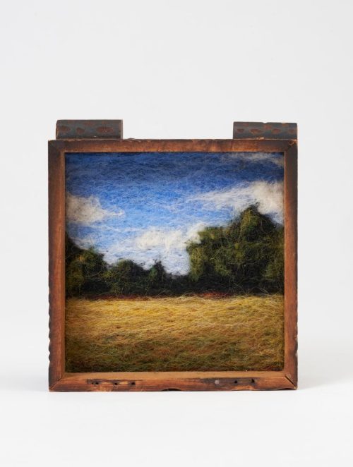 A needle felted landscape set in a vintage wood box titled Field by Jaana Mattson.